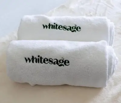 two white towels with the word wilderness written on them at White Sage - Act One Tower in Dubai