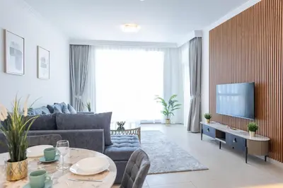 a living room with a couch and a tv at Al Bateen Resdences by HAPPY SEASON JBR in Dubai