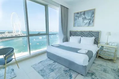 a bedroom with a large bed and a large window at Al Bateen Resdences by HAPPY SEASON JBR in Dubai