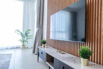 a living room with a television on a wall with plants at Al Bateen Resdences by HAPPY SEASON JBR in Dubai