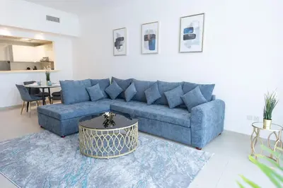 a living room with a blue couch and a table at Al Bateen Resdences by HAPPY SEASON JBR in Dubai