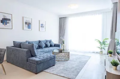 a living room with a blue couch and a rug at Al Bateen Resdences by HAPPY SEASON JBR in Dubai