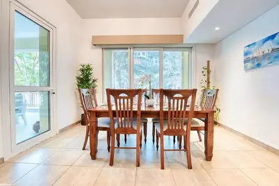 a dining room with a wooden table and chairs at Direct Access to Nakheel Mall At the Heart of The Palm in Dubai