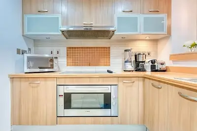 a kitchen with wooden cabinets and a microwave at Direct Access to Nakheel Mall At the Heart of The Palm in Dubai