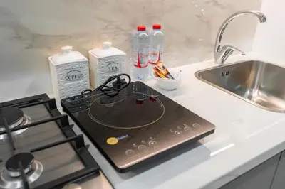 a laptop sitting on a kitchen counter next to a sink at Nice Studio in Azizi Riviera 32 - Dubai in Dubai