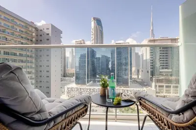 a balcony with two chairs and a table in front of a window at Frank Porter - Vera Residence in Dubai