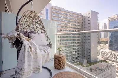 a swing on a balcony with a view of a city at Frank Porter - Vera Residence in Dubai