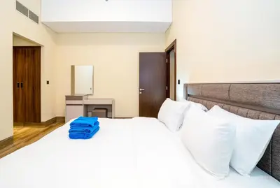 a bedroom with a large white bed with blue towels on it at New Arabian 2 Bedroom J One Tower Business Bay in Dubai