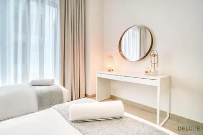 a white bedroom with a dressing table and a mirror at Capacious 2BR at Sunset at Creek Beach 3 Dubai Creek Harbor by Deluxe Holiday Homes in Dubai