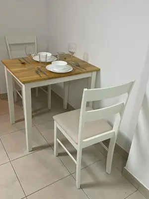 a white table with a white chair and a table with glasses at Studio close to Burj Khalifa and Downtown Dubai in Dubai