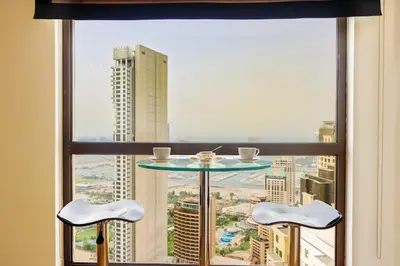 a table and two chairs in front of a window at Stunning 1BR with Palm and Sea Views in Dubai