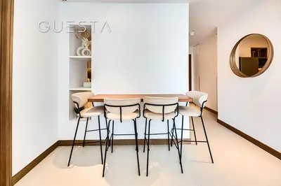 a dining room with a table and stools at Vida Residences Dubai Marina by Emaar in Dubai