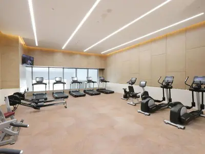 a gym with rows of exercise bikes and treadmills at Livbnb Suites - 1BR w/ Sea View in Palm Tower in Dubai