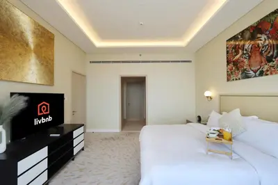 a hotel room with a large bed and a television at Livbnb Suites - 1BR w/ Sea View in Palm Tower in Dubai