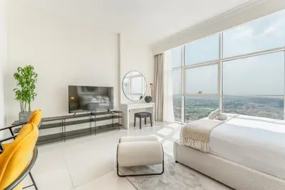 a bedroom with a large bed and a large window at Studio in Reef Residence JVC by PK Holidays in Dubai