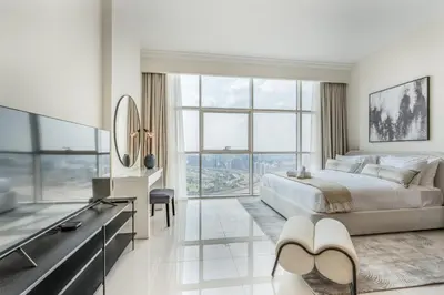 a bedroom with a large bed and a large window at Studio in Reef Residence JVC by PK Holidays in Dubai