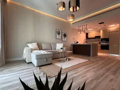 a living room with a couch and a kitchen at Modern-Chic 1BR in The Greens - Central Dubai in Dubai