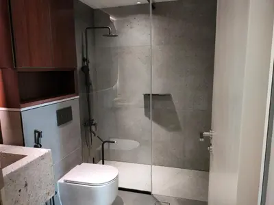 a bathroom with a glass shower with a toilet at Modern-Chic 1BR in The Greens - Central Dubai in Dubai