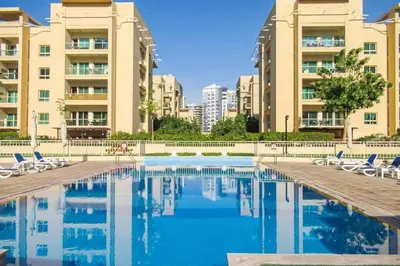 a swimming pool with chairs and some buildings at Modern-Chic 1BR in The Greens - Central Dubai in Dubai