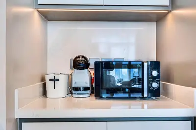 a kitchen counter with a coffee maker and a microwave at Emaar Beachfront Sunrise Bay 2bdr apartment in Dubai