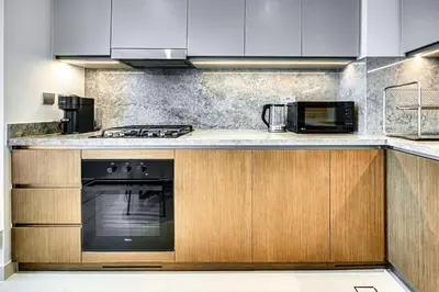 a kitchen with a stove and a microwave at Phenomenal 2BD with the beach in Dubai