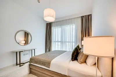 a bedroom with a bed and a mirror and a window at Phenomenal 2BD with the beach in Dubai
