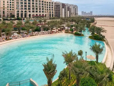 a large swimming pool with a beach and buildings at Nice 1BD Apartment in Surf at Creek Beach in Dubai