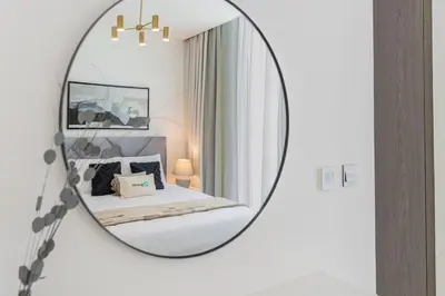 a bedroom with a mirror on a wall at HiGuests - Step Into Heaven In This Lakeside Apartment in Dubai