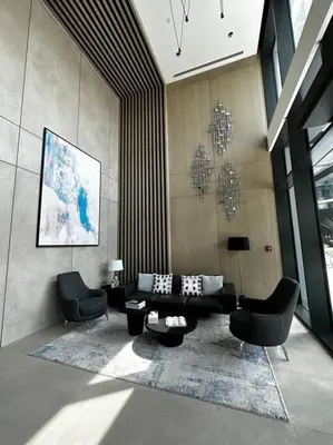 a living room with two chairs and a couch at Prime 1BR in Sobha Hartland, Burj Khalifa view in Dubai