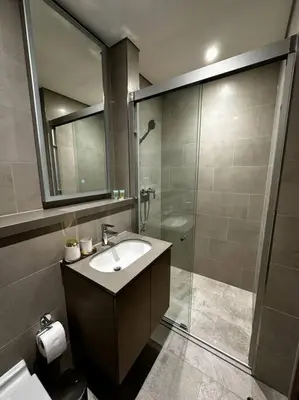 a bathroom with a sink and a shower at Prime 1BR in Sobha Hartland, Burj Khalifa view in Dubai