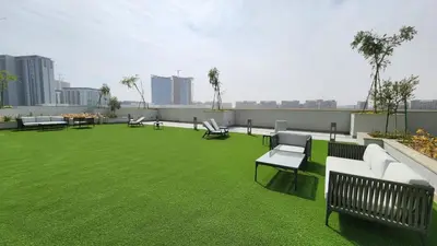 a rooftop patio with green grass and benches on a building at STAY BY LATINEM Luxury 1BR Holiday Home CVR A413 near Burj Khalifa in Dubai