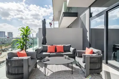 a living room with a couch and a table on a balcony at Guestready - Grey Pearl with Big Balcony in Dubai