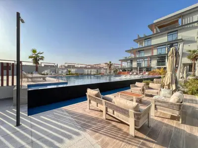 an outdoor patio with chairs and a pool at Guestready - Grey Pearl with Big Balcony in Dubai