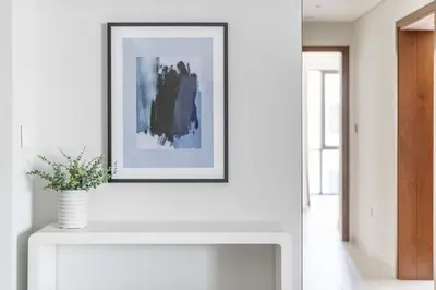 a picture frame on a white wall above a fireplace at GuestReady - Lux living with an infinity pool in Dubai