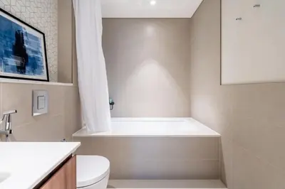a bathroom with a tub and a toilet and a sink at GuestReady - Lux living with an infinity pool in Dubai