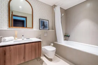 a bathroom with a sink and a toilet and a bath tub at GuestReady - Lux living with an infinity pool in Dubai