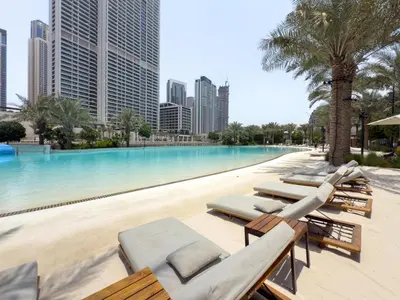 a swimming pool with chaise lounges and a resort at GuestReady - Lux living with an infinity pool in Dubai