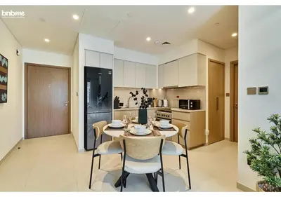 a kitchen and dining room with a table and chairs at bnbme - Chic 1BR Apt w Balcony Pool Gym Access Steps to Burj Khalifa & Dubai Mall in Dubai