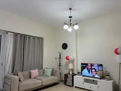 a living room with a couch and a flat screen tv at Studio Apartment - Cozy, Very Accessible and so near to Train Station in Dubai