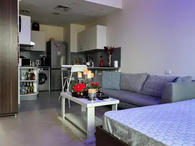a living room with a couch and a table at Studio Apartment - Cozy, Very Accessible and so near to Train Station in Dubai