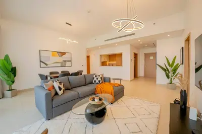 a living room with a couch and a table at Lux Golf Views 3 BR in Emirates Hills in Dubai