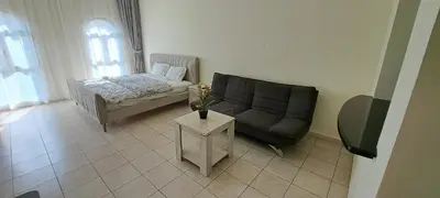 a living room with a couch and a table at DRUVYA HOLIDAY HOMES, Bld DG083, Street No,3 Discovery Gardens, Close to The Gardens Metro 6 minutes walkable in Dubai