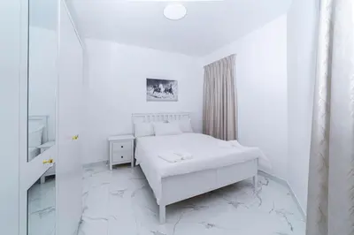 a white bedroom with a bed and a mirror at Luxury 2 Bedroom Apartment in Dubai Marina & JBR Beach in Dubai
