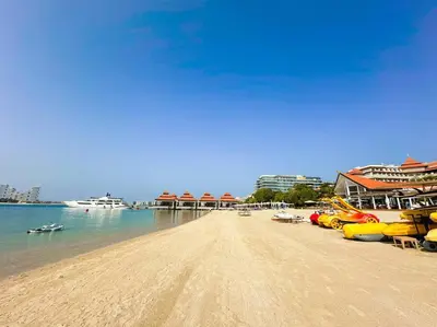a sandy beach with boats on the water at Family friendly apt at Palm in Dubai