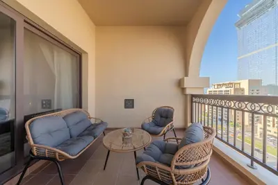 a balcony with couches and a table and chairs at Modern 1BR in Vibrant Fairmont North Residence - 90AB6 in Dubai