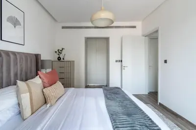 a bedroom with a large bed and a pendant light at GuestReady - Exquisite residence in Dubai Marina in Dubai