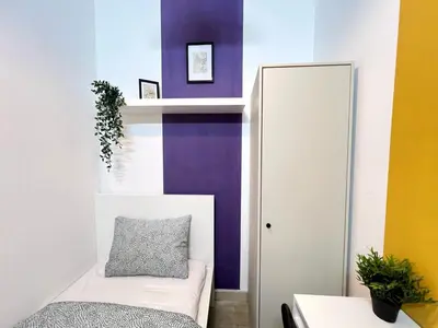 a bedroom with purple and white walls and a bed at Arch Partition Room Near Mall of the Emirates in Dubai