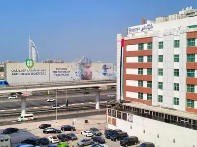 a parking lot with cars on a highway next to a building at Arch Partition Room Near Mall of the Emirates in Dubai