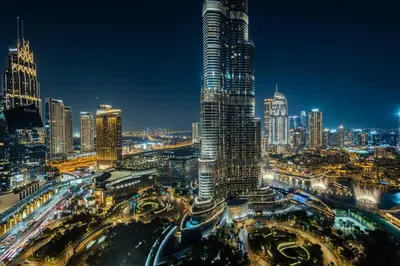 a city skyline at night with a tall skyscraper at Stunning Full Burj Khalifa View - The Address 2BR Luxury in Dubai