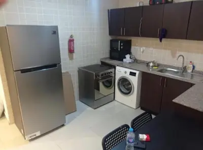 a kitchen with a refrigerator and a washing machine at Dreamy Partition Room in Barsha1 in Dubai